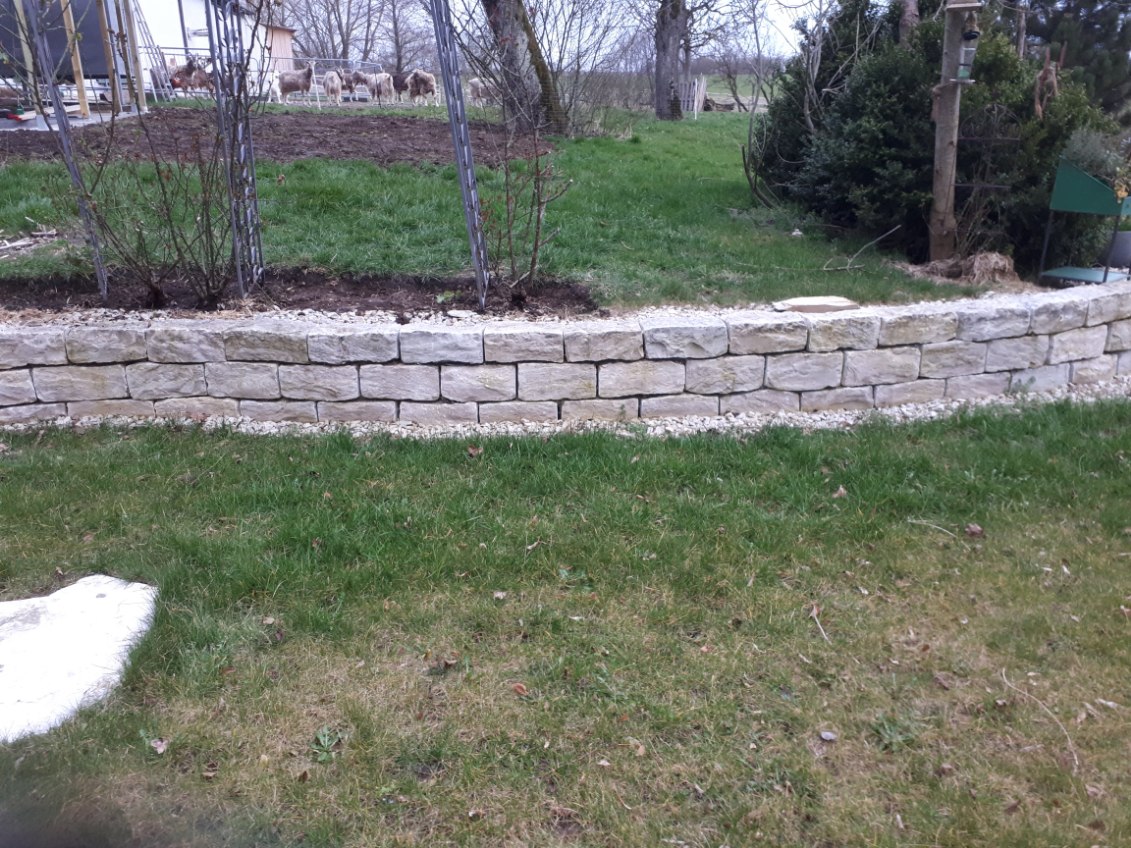 Trockenmauern aus Naturstein als Hangabstützung und Beetumrandung